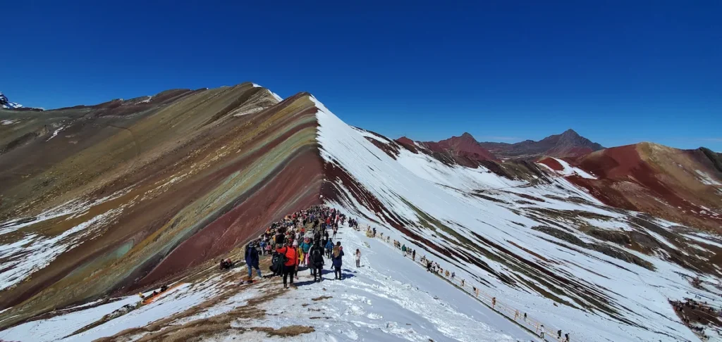 Impresionante vista de la Montaña de 7 Colores (Vinicunca), mostrando el contraste del paisaje con y sin nieve.
